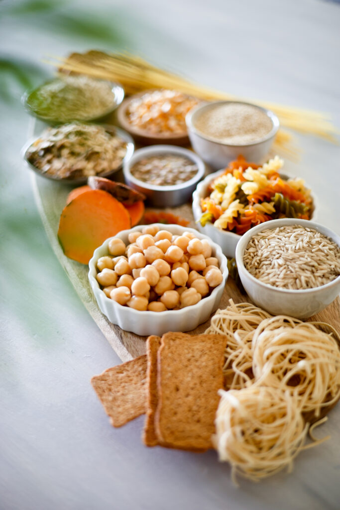 board with carbohydrate sources - pasta, chickpeas, rice, cereals, toasts, sweet potatoes